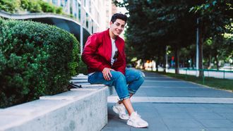 knappe jongen zit op een stoepje