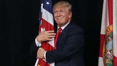 Donald Trump knuffelt Amerikaanse vlag