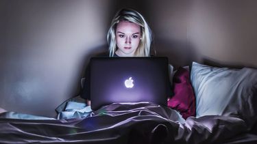 Meisje op laptop in donkere kamer, Netflix account gebruiker